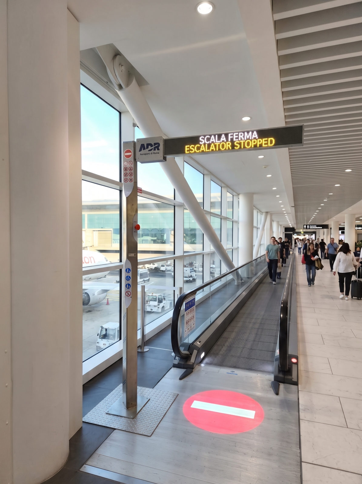 Colonna ViewTower accanto a un tappeto mobile: il display LED segnala l'impianto fermo e la segnalazione luminosa è proiettata a pavimento.